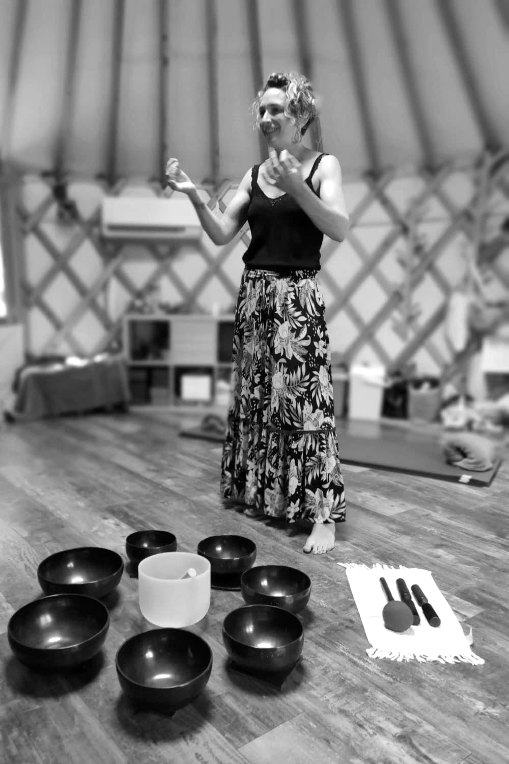 Johanna sous une yourte, derrière un cercle de bols tibétains.